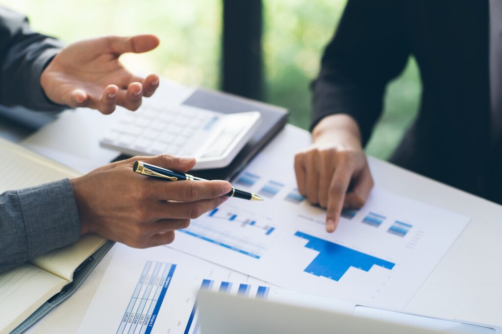 Two colleagues discussing data with document data on desk table. Close up business people meeting